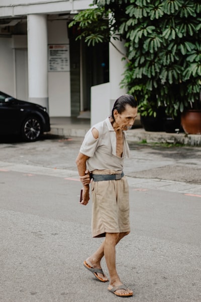 穿着棕色短裤的男子站在水泥路上
